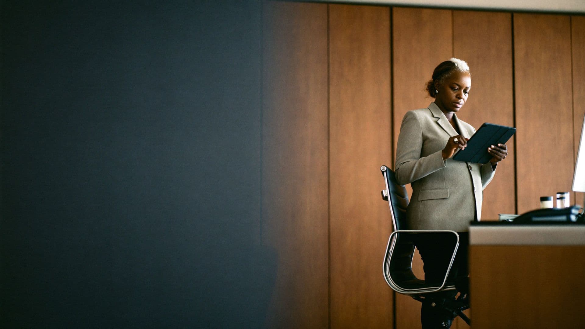 Chief executive reviewing a tablet in a wood-panelled office